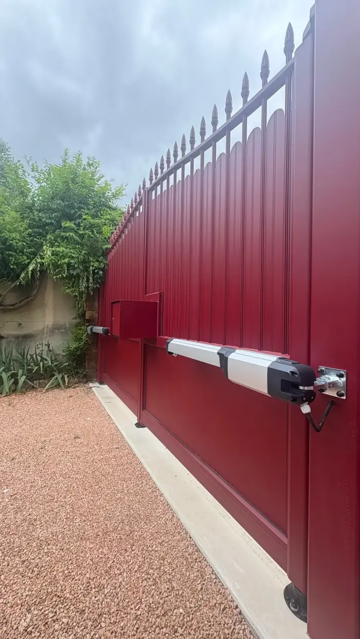 moteur BFT Phobos posé par VVS Automatismes sur portail battant aluminium de couleur rouge